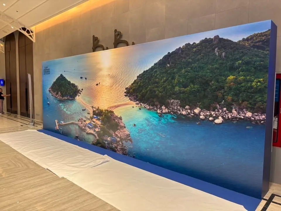จอไฟขนาดใหญ่แสดงภาพเกาะทะเลไทยยามพระอาทิตย์ตก บริเวณต้อนรับงาน AFF Ordinary Congress 2025