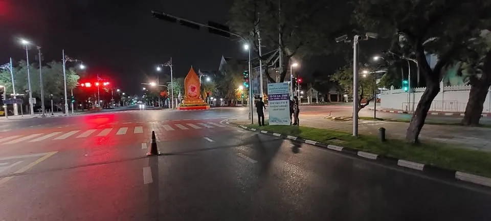 มุมกว้างสี่แยกถนนยามค่ำคืน มีป้ายประชาสัมพันธ์ ASICS META : Time : Trials ริมทาง