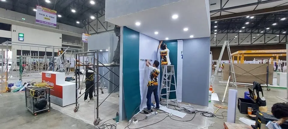 ทีมช่างกำลังติดตั้งงานตกแต่งบูธหน้างาน