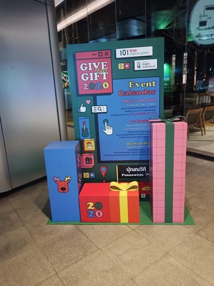 ป้าย Give 'em Gift 2020 พร้อมกล่องของขวัญบริเวณสวนยามค่ำคืน