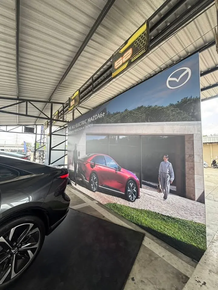 ป้ายแบ็คดรอป Premiere Test Drive พร้อมรถ MAZDA6e สีดำจอดหน้าป้าย