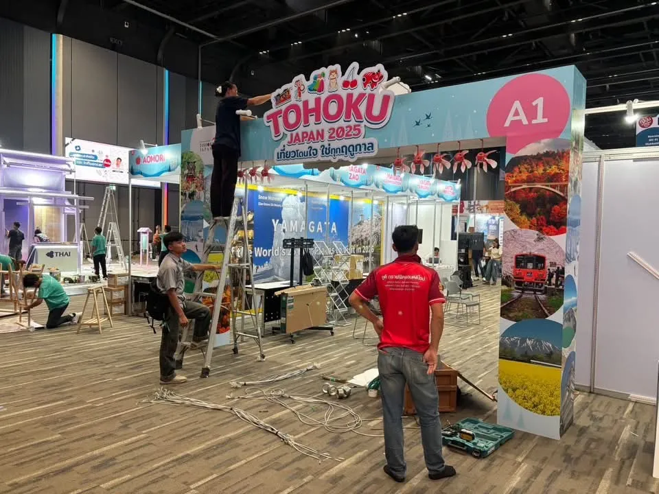 ทีมช่างกำลังติดตั้งป้ายซุ้มทางเข้างาน Tohoku Japan 2025 บนบันได