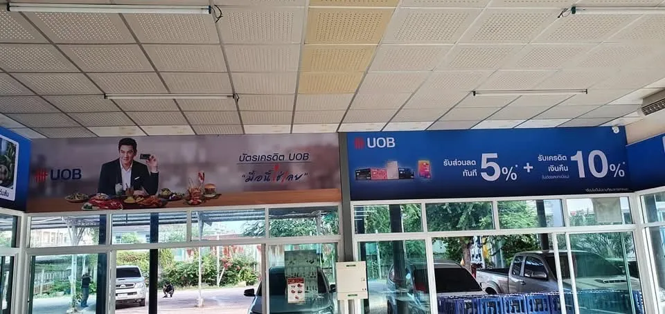 ป้ายโฆษณาบัตรเครดิต UOB ติดเหนือทางเข้าร้านอาหาร มองจากภายนอกยามกลางวัน