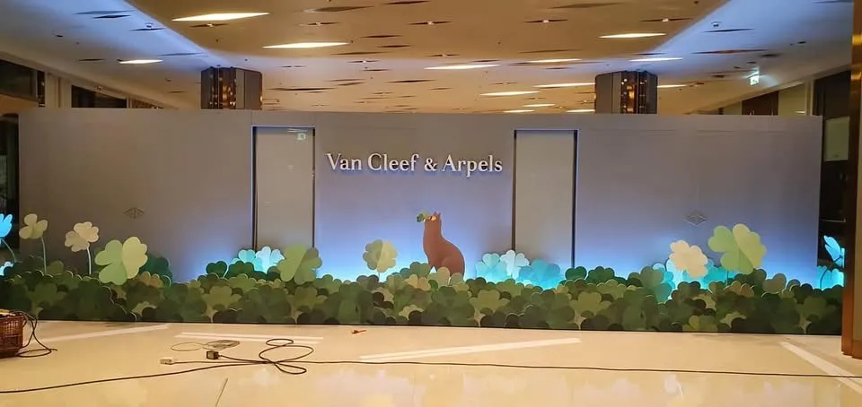 ผนังกั้นตกแต่ง Van Cleef & Arpels พร้อมกราฟิกกวางและพุ่มไม้